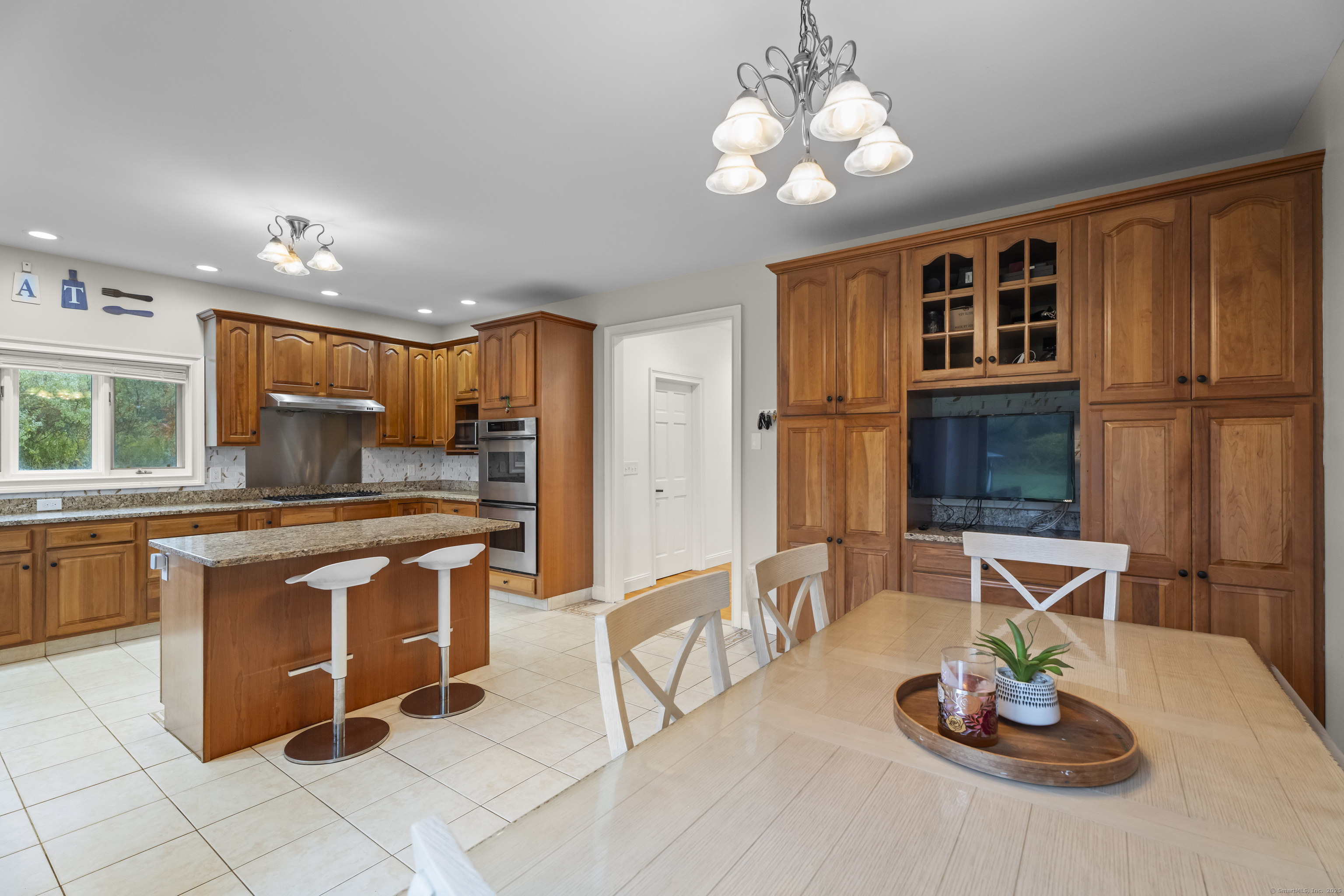 305 Killorin Road Watertown, CT 06795 - Photo 14 of 40 a kitchen with stainless steel appliances granite countertop a stove a refrigerator a sink a dining table and chairs with wooden floor