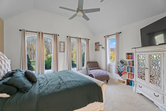 a bedroom with a bed furniture and flat tv screen