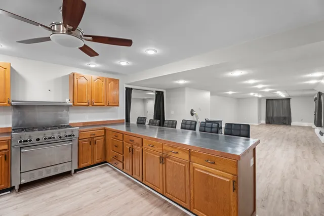 a large kitchen with stainless steel appliances granite countertop a stove and a sink