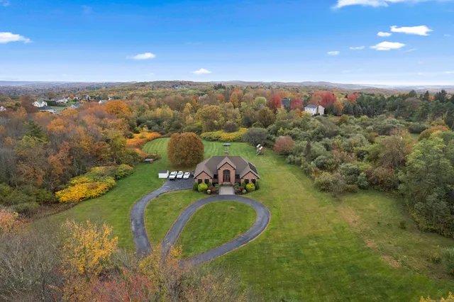an aerial view of a house with a yard and lake view