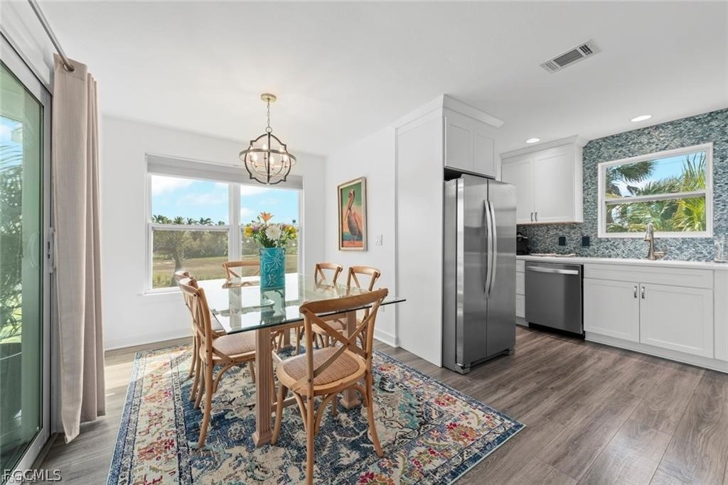 6093 Henderson Road Sanibel, FL 33957 - Photo 12 of 49 a kitchen with granite countertop a table chairs stove a refrigerator and a view of living room
