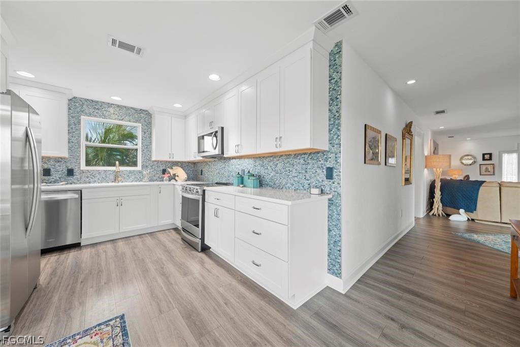6093 Henderson Road Sanibel, FL 33957 - Photo 13 of 49 a kitchen with white cabinets sink and white appliances