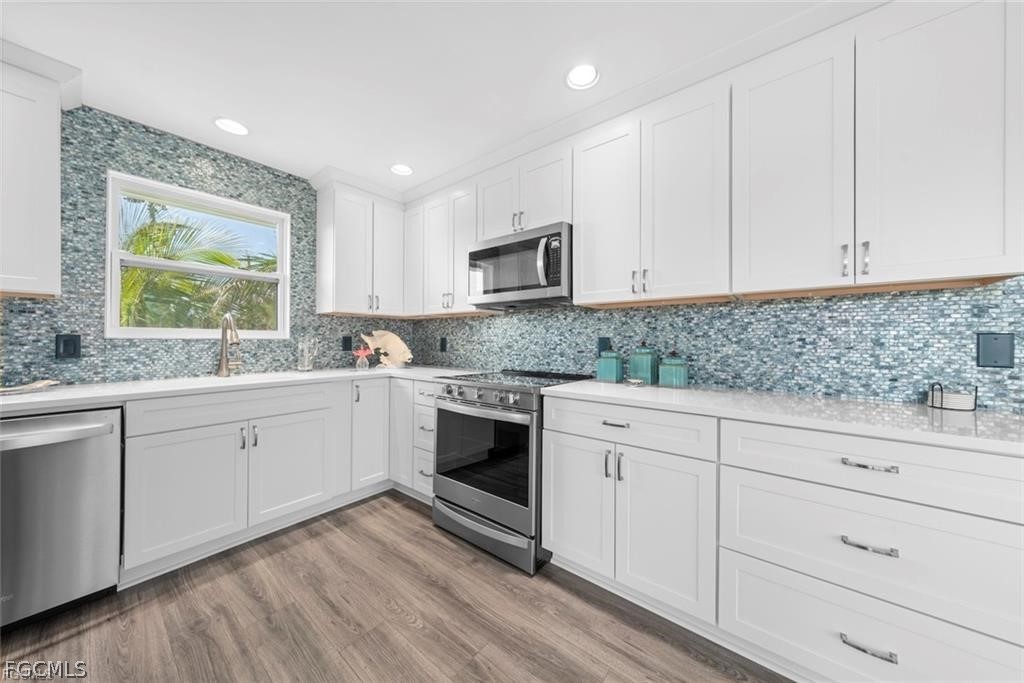 6093 Henderson Road Sanibel, FL 33957 - Photo 15 of 49 a kitchen with granite countertop white cabinets white stainless steel appliances and sink
