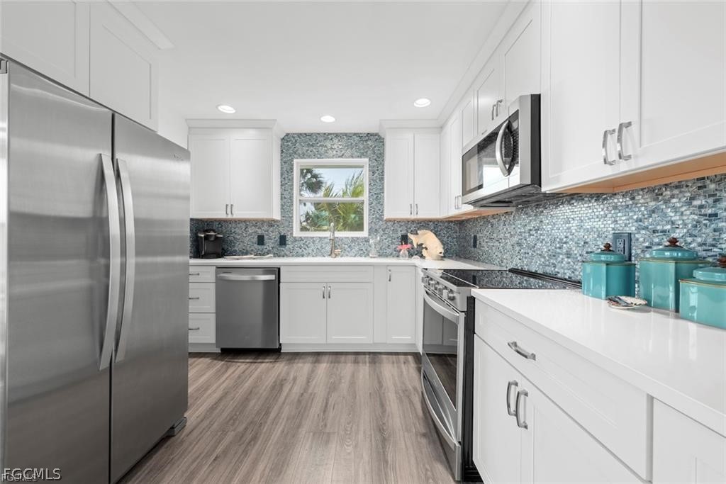 6093 Henderson Road Sanibel, FL 33957 - Photo 17 of 49 a kitchen with a sink stove and refrigerator