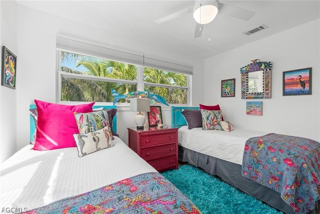 6093 Henderson Road Sanibel, FL 33957 - Photo 29 of 49 a bedroom with a bed and a chandelier