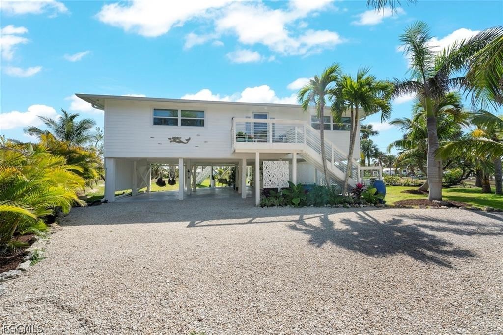 6093 Henderson Road Sanibel, FL 33957 - Photo 38 of 49 a front view of a house with a yard and garage
