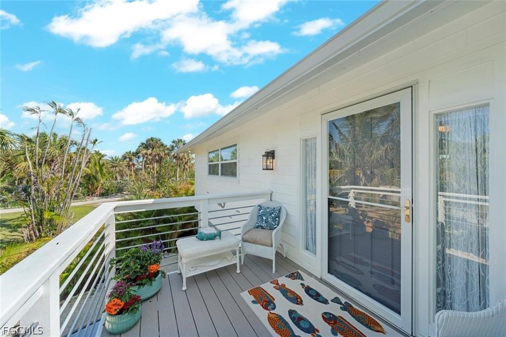 6093 Henderson Road Sanibel, FL 33957 - Photo 6 of 49 a balcony with furniture and wooden floor