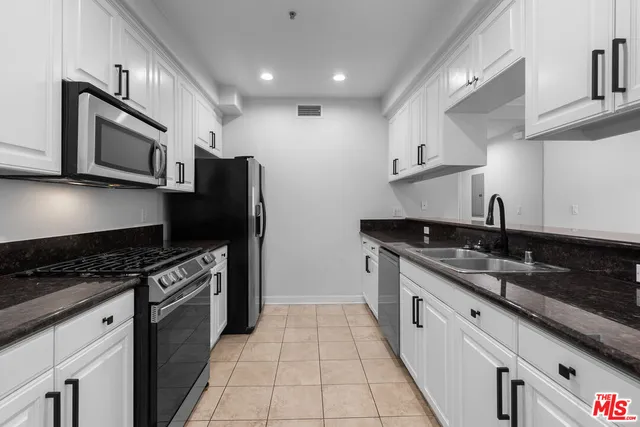 a kitchen with stainless steel appliances granite countertop a sink and a stove