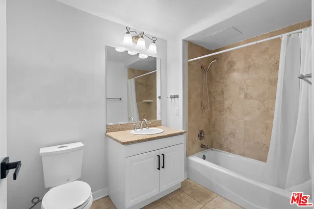 a bathroom with a granite countertop sink a toilet and shower