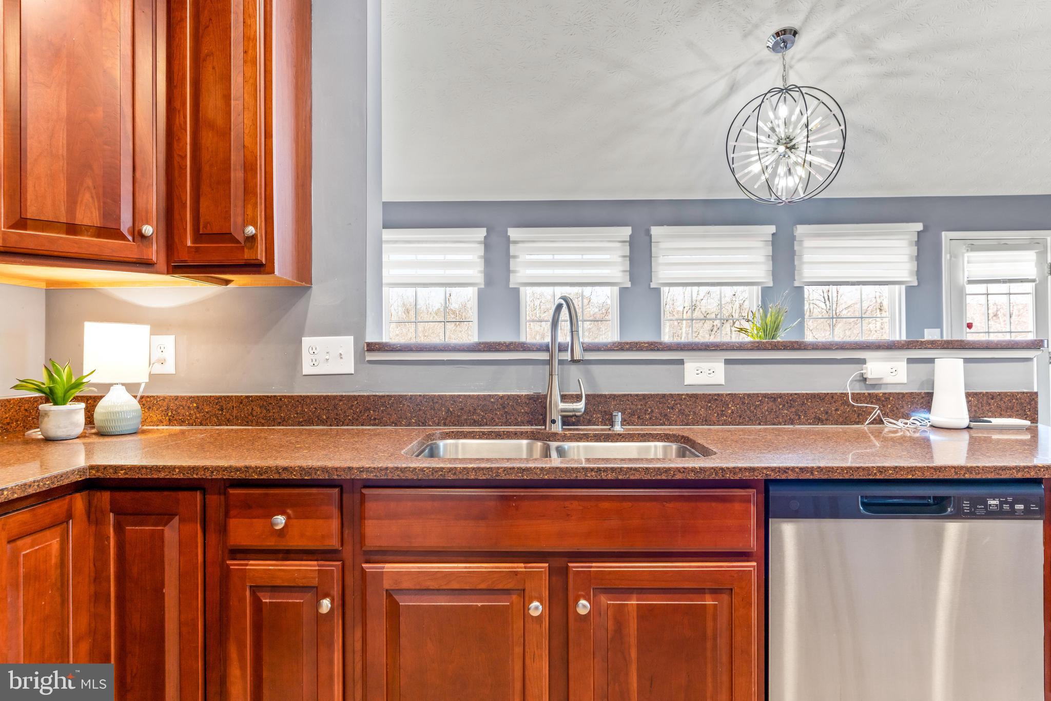1717 Maco Drive Hanover, MD 21076 - Photo 16 of 93 a kitchen with stainless steel appliances granite countertop a sink dishwasher a stove and a dining table with wooden floor