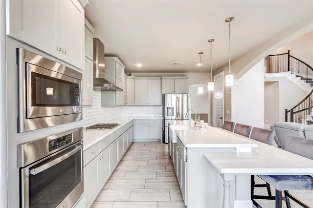 a large kitchen with kitchen island a stove a sink a dining table and chairs