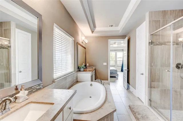 a spacious bathroom with a granite countertop tub sink and mirror