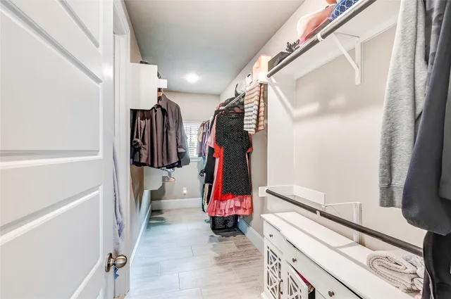 a view of walk in closet with clothes and shoes