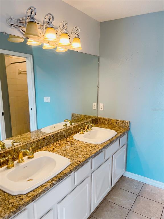 427 Eagle Ridge Drive Davenport, FL 33837 - Photo 18 of 39 a bathroom with a granite countertop sink and a mirror