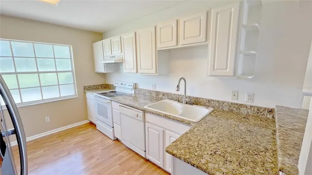 a kitchen with stainless steel appliances granite countertop a sink stove and cabinets