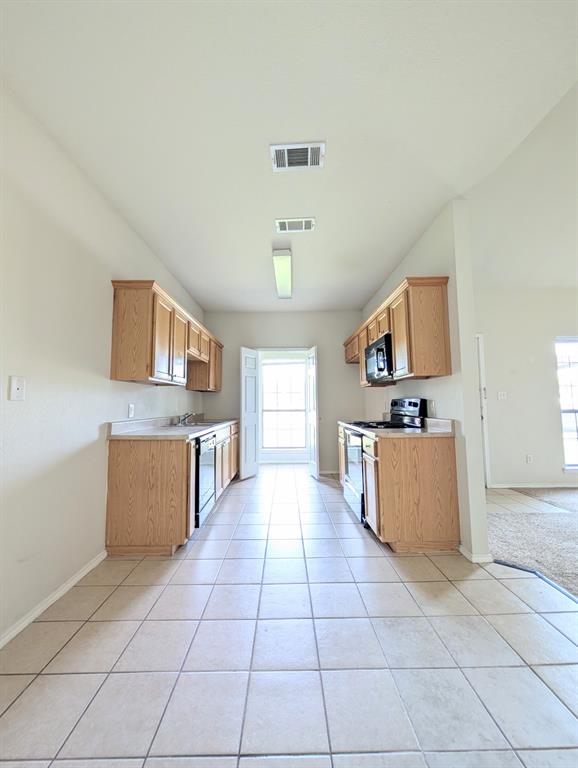 120 Collett Court Weatherford, TX 76088 - Photo 5 of 10 a large kitchen with stainless steel appliances a stove a sink dishwasher and a refrigerator with white cabinets
