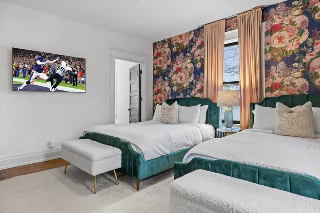 a bedroom with 2 bed and a painting on the wall