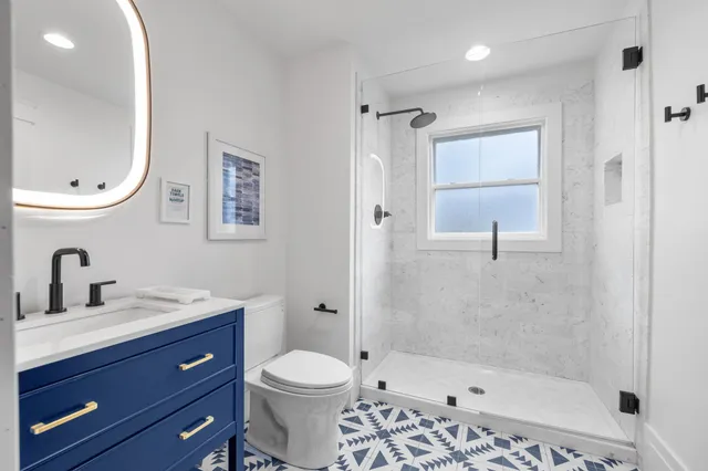 a bathroom with a bathtub shower sink mirror and toilet