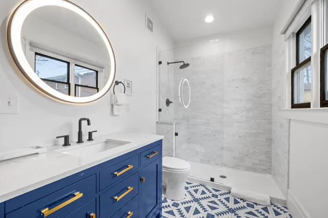 a bathroom with a sink a toilet and a mirror