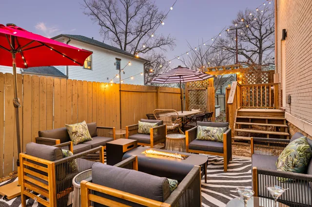 a backyard of a house with barbeque oven table and chairs