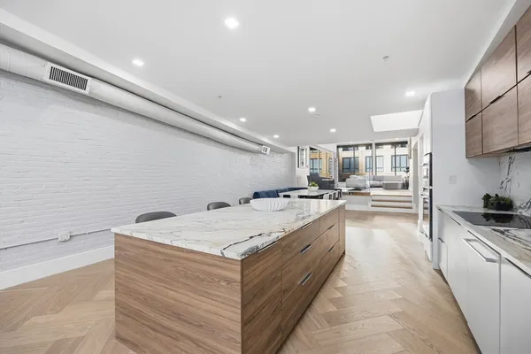 a large white kitchen with a stove a sink a refrigerator and a counter space