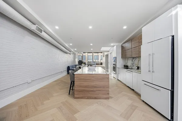 a large white kitchen with a refrigerator a stove and a sink