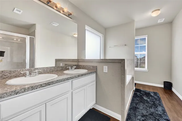 a spacious bathroom with a granite countertop sink and a mirror