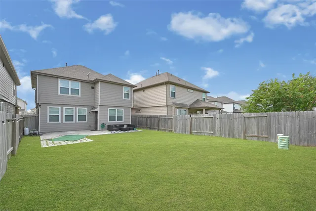 a view of a house with a yard and a large tree