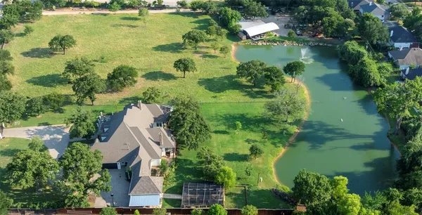an aerial view of residential houses with outdoor space and trees all around