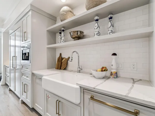 a dining hall with stainless steel appliances granite countertop a stove a sink a dining table and chairs