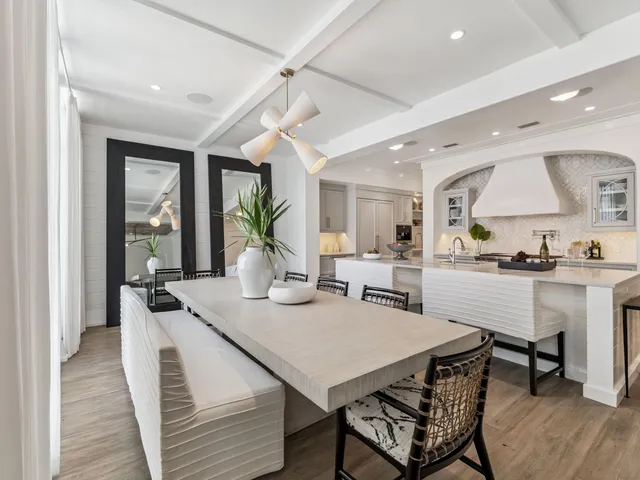 a kitchen with a sink a stove and chairs with wooden floor