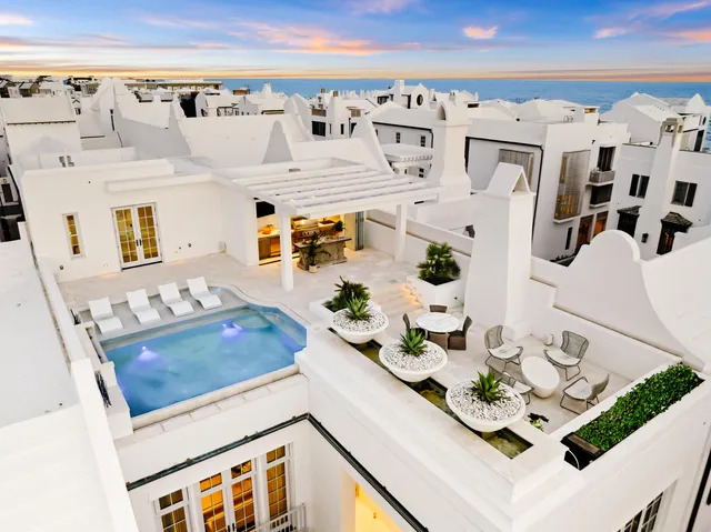 a living room with white furniture and decor