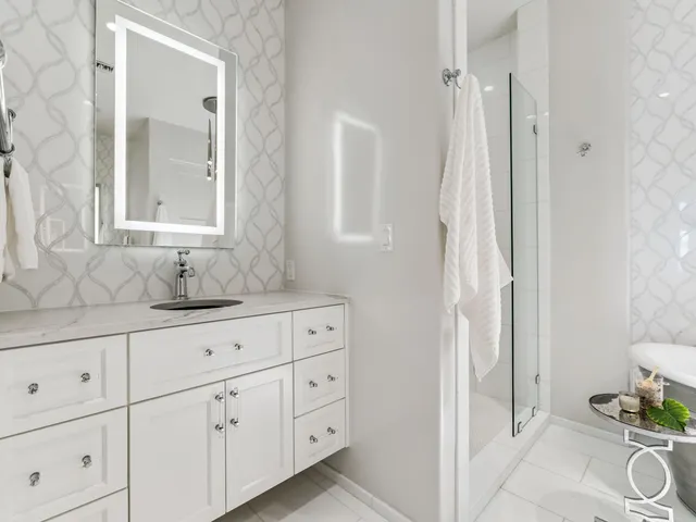 a bathroom with white cabinets