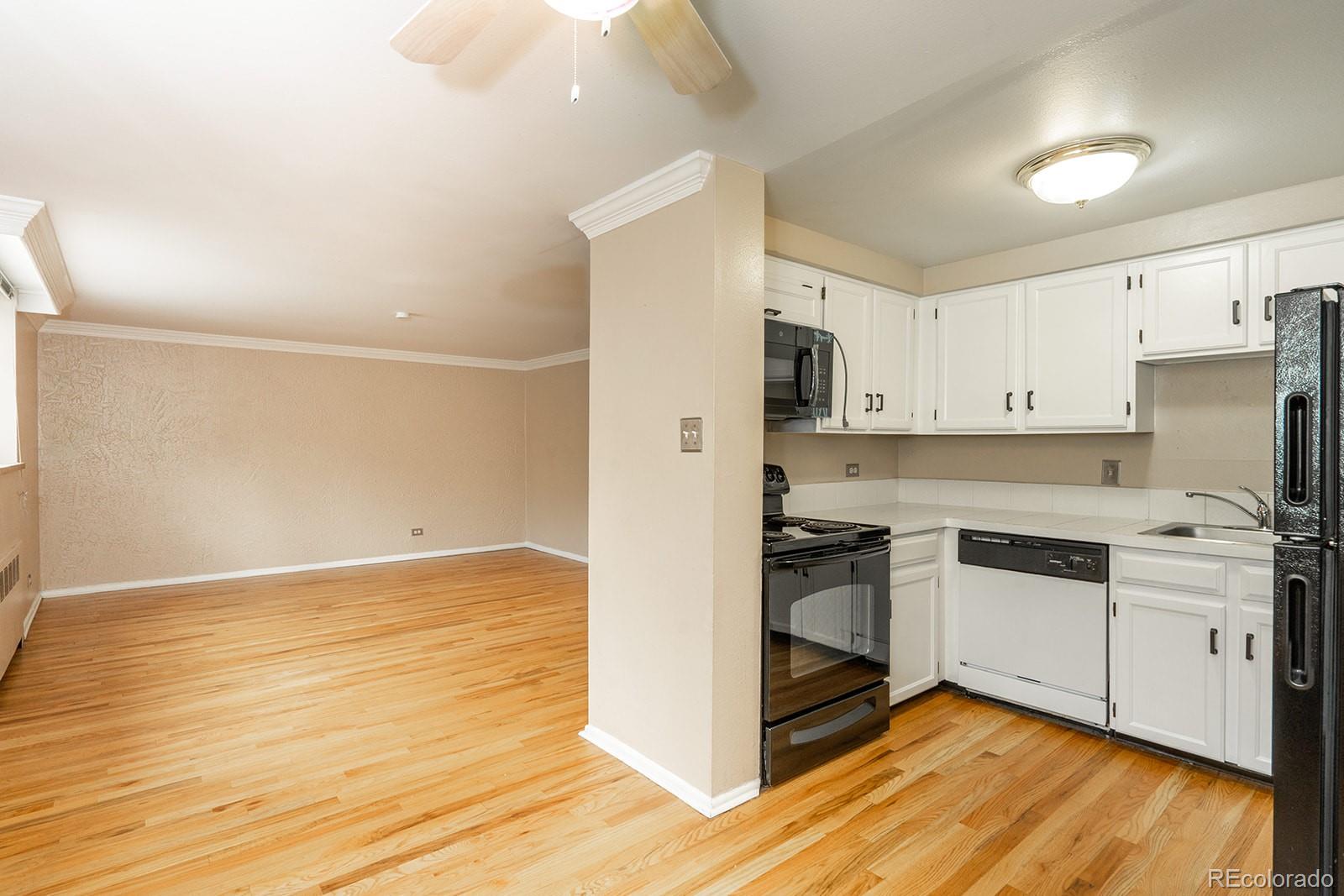 1350 Josephine Street, Unit 101 Denver, CO 80206 - Photo 12 of 13 a kitchen with stainless steel appliances granite countertop a stove and a refrigerator