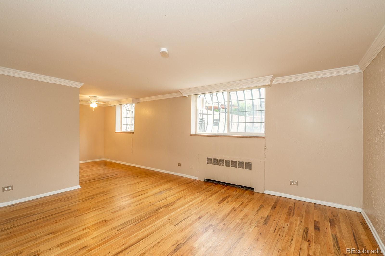 1350 Josephine Street, Unit 101 Denver, CO 80206 - Photo 10 of 13 an empty room with wooden floor and windows