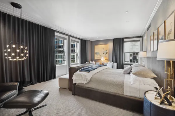 a bedroom with a bed couch and a potted plant