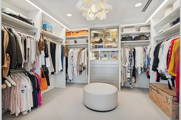 a view of walk in closet with clothes and shoes