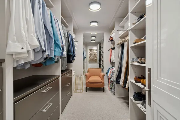 a view of walk in closet with clothes and shoes