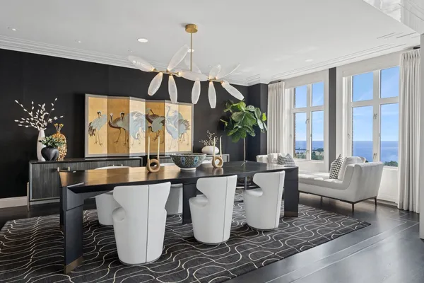 a dining room with large glass table and chairs