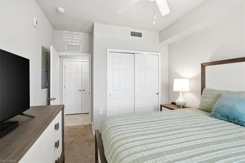 a bedroom with a bed and a tv on the dresser