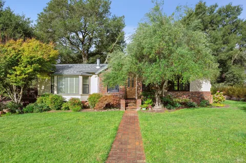 a front view of a house with a yard and trees