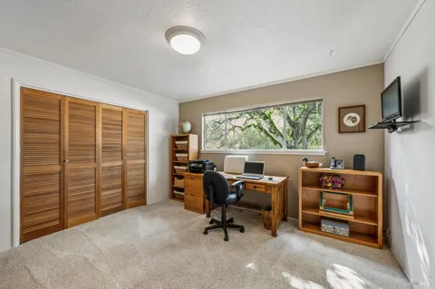 a view of a livingroom with workspace and a window