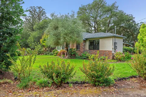 a view of a house with a yard and potted plants
