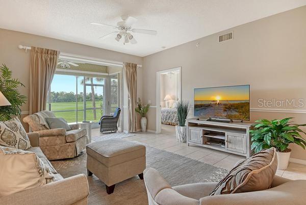 9641 Castle Point Drive, Unit 1215 Sarasota, FL 34238 - Photo 14 of 48 a living room with furniture and a flat screen tv