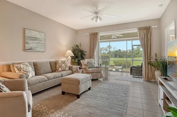 a living room with furniture and a large window with balcony view