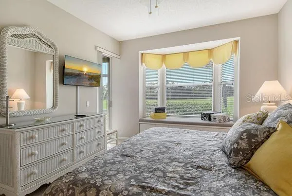 a bedroom with a bed and large windows