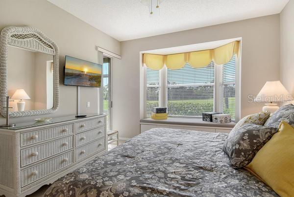 9641 Castle Point Drive, Unit 1215 Sarasota, FL 34238 - Photo 17 of 48 a bedroom with a bed and large windows