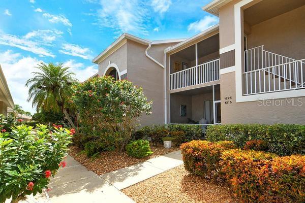 9641 Castle Point Drive, Unit 1215 Sarasota, FL 34238 - Photo 2 of 48 a front view of a house with garden