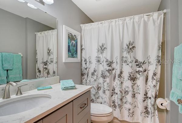9641 Castle Point Drive, Unit 1215 Sarasota, FL 34238 - Photo 21 of 48 a bathroom with a granite countertop sink a toilet and a mirror