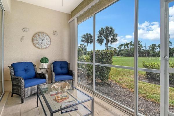 9641 Castle Point Drive, Unit 1215 Sarasota, FL 34238 - Photo 24 of 48 a living room with couch and a floor to ceiling window